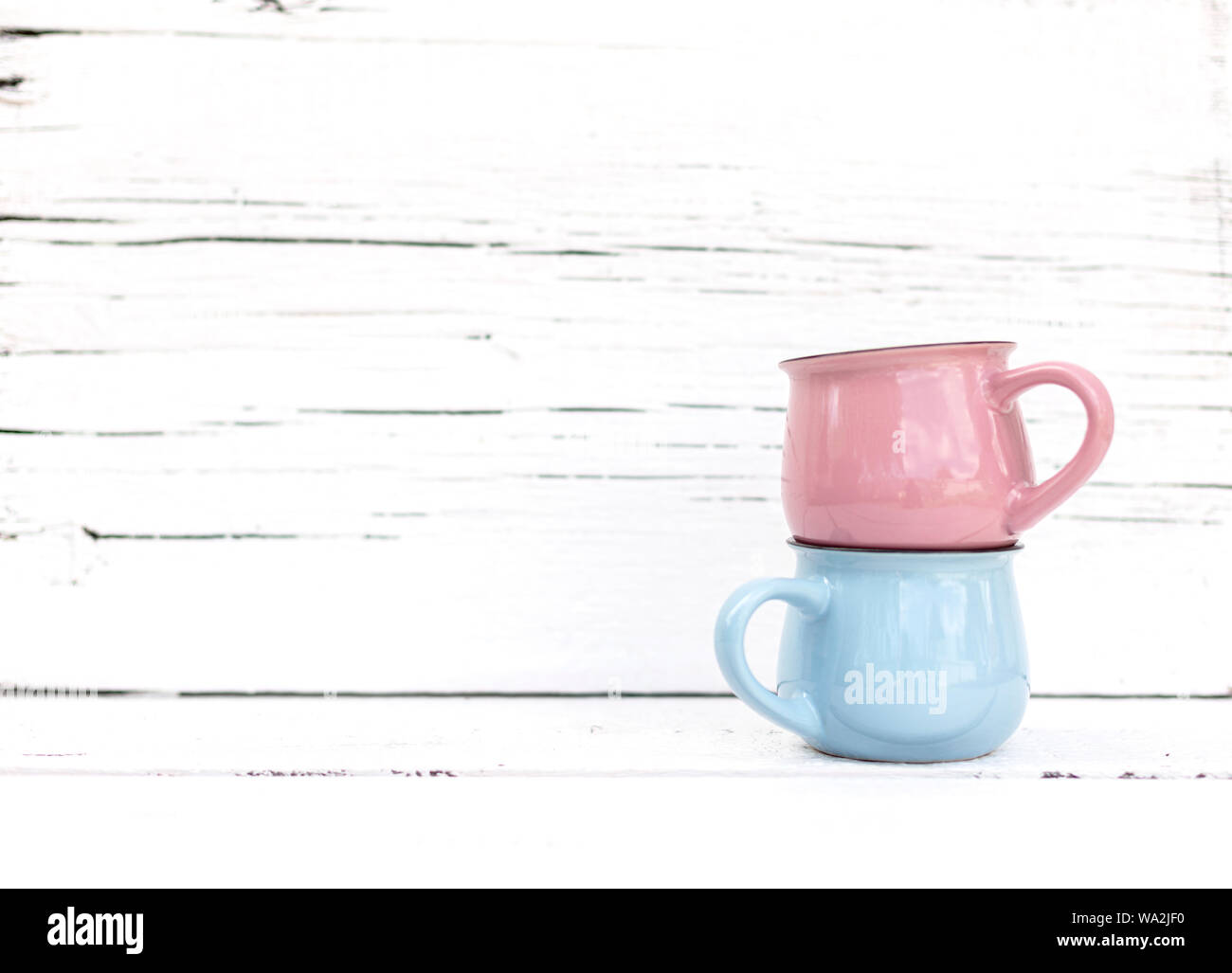 Enameled mugs in retro style on an old wooden background. Selective focus. Stock Photo