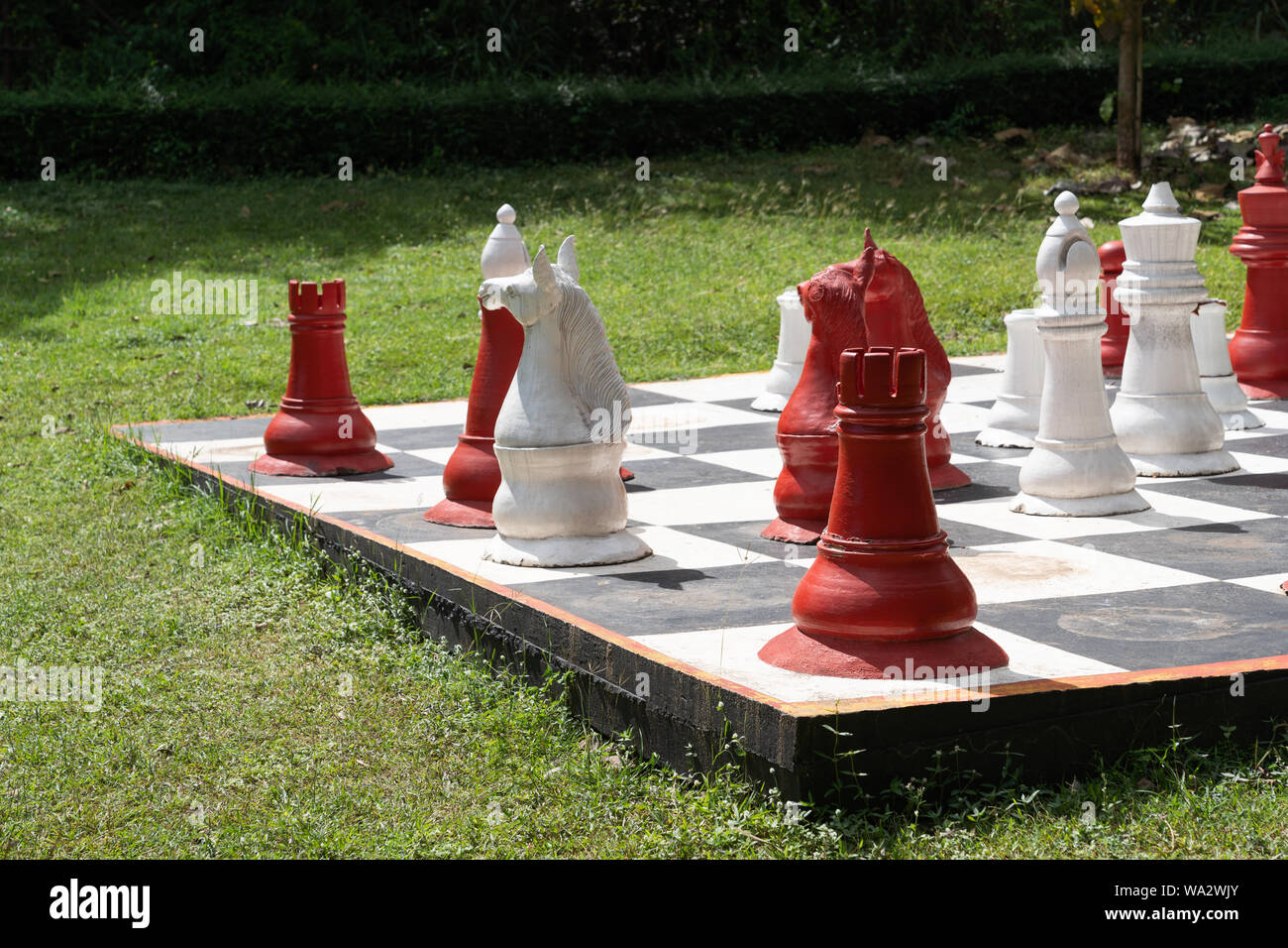 Vintage big chess, White and red chess in the garden background. Stock Photo