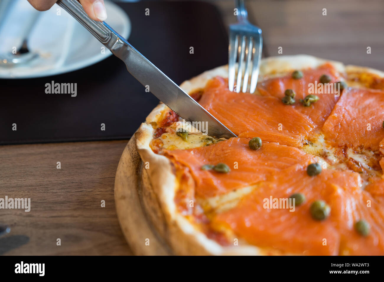 Close up. Full delicious fresh salmon pizzas on wood table, in luxury restaurant, italian pizza food concept. Stock Photo
