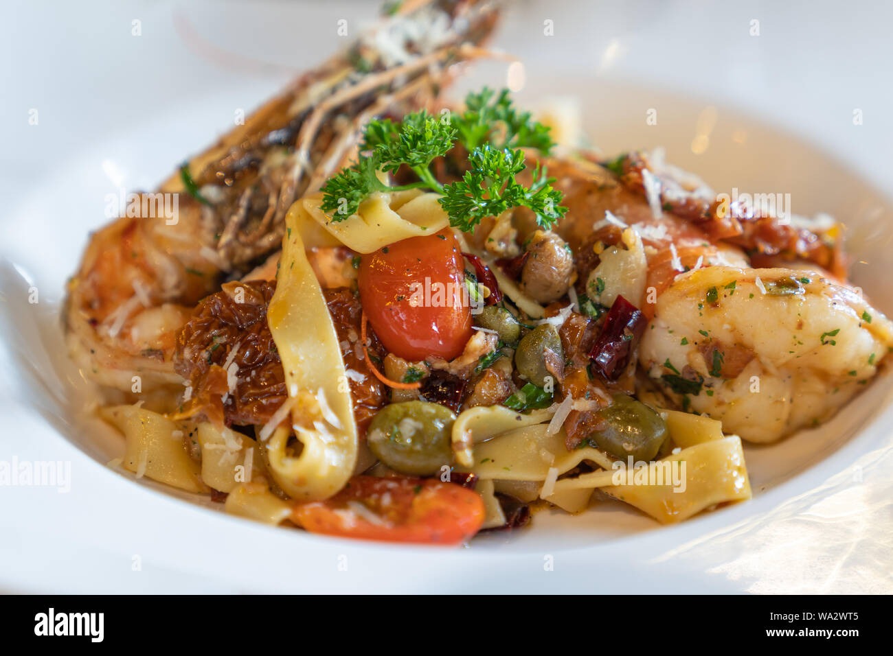 Close up. Delicious fresh spaghetti seafood with big shrimp dipping, on white dish, in luxury restaurant, italian pizza food concept. Stock Photo
