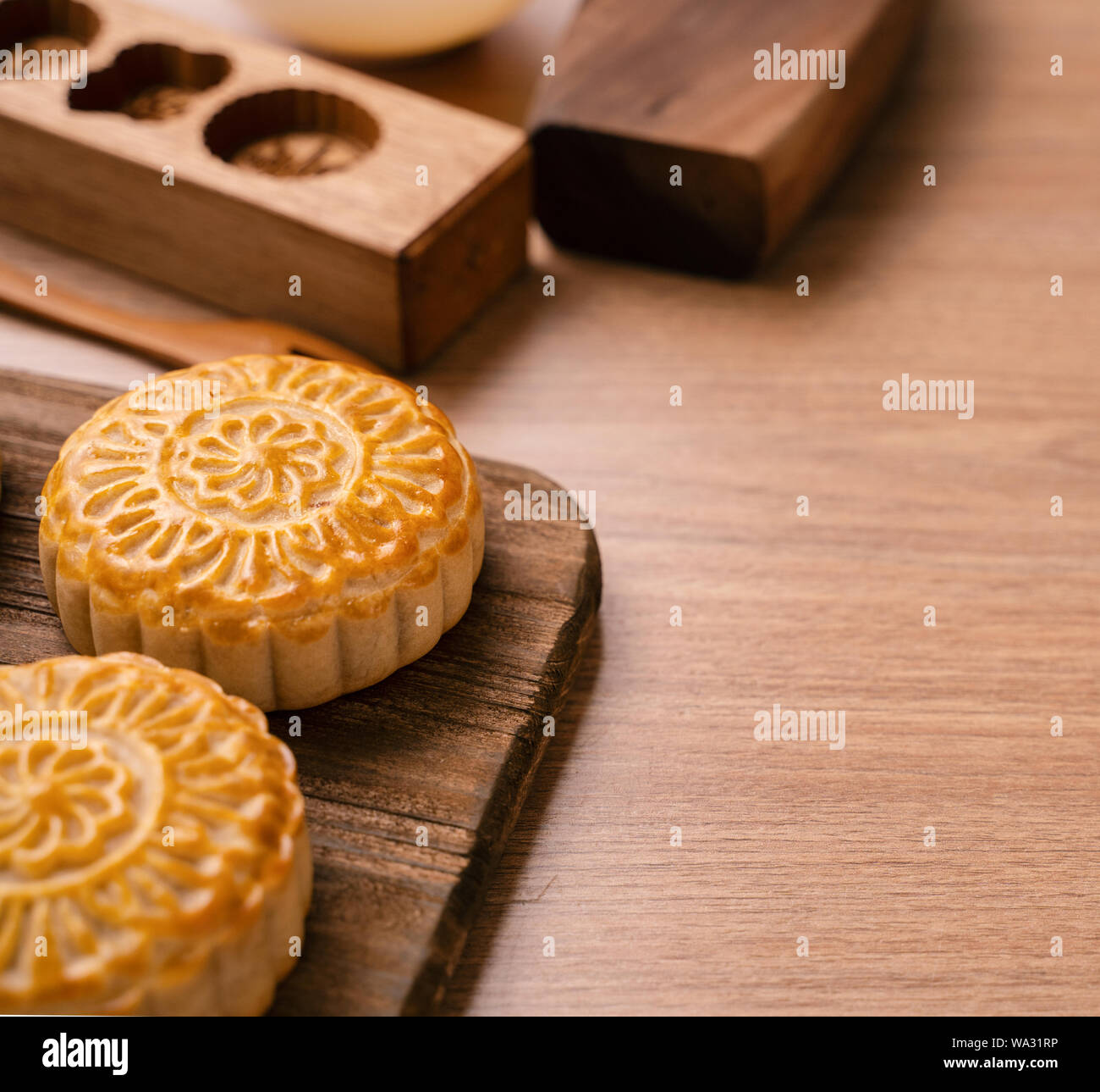 Round shaped fresh baked moon cake pastry - Chinese moonckae for Mid-Autumn Moon Festival on wooden background and serving tray, close up, copy space Stock Photo