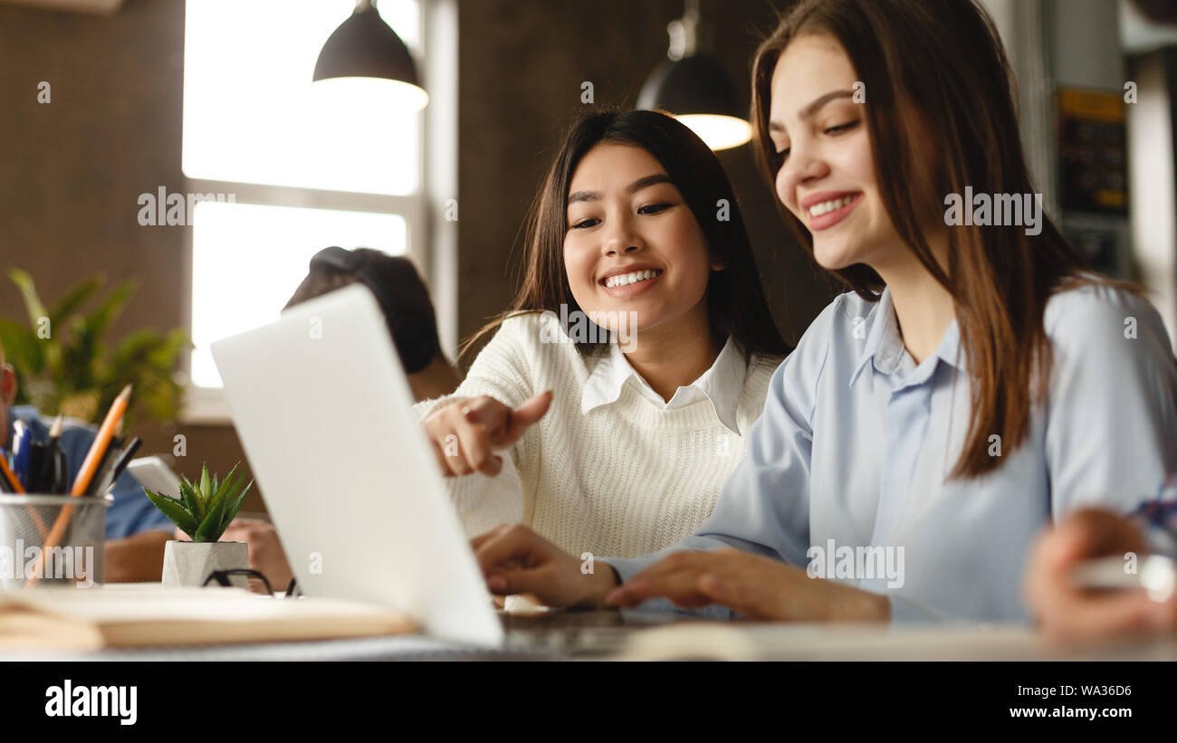 Happy student girls doing project together on laptop Stock Photo - Alamy