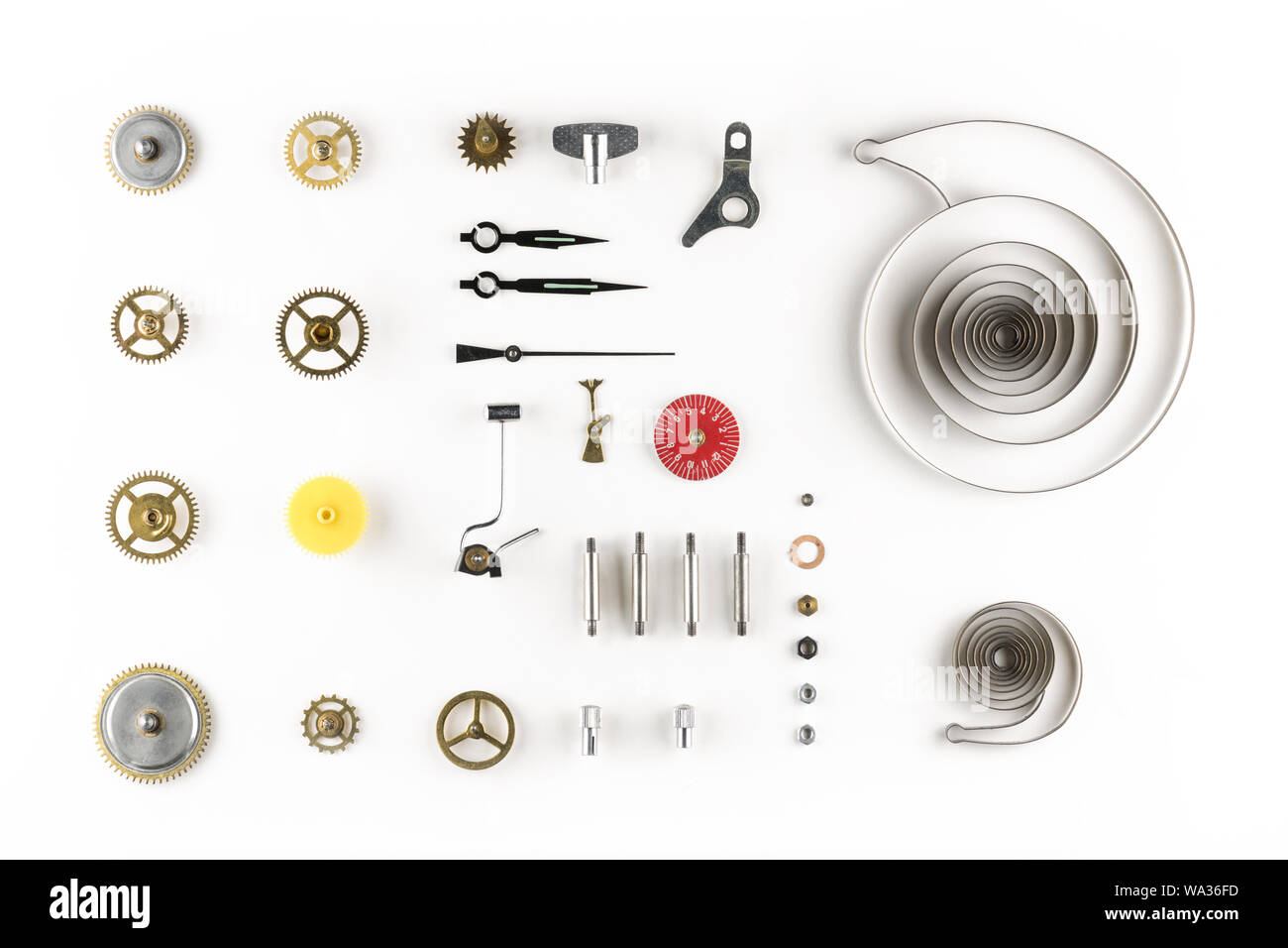 top view of aligned dissassambled parts of a vintage alarm clock mechanism on white background Stock Photo