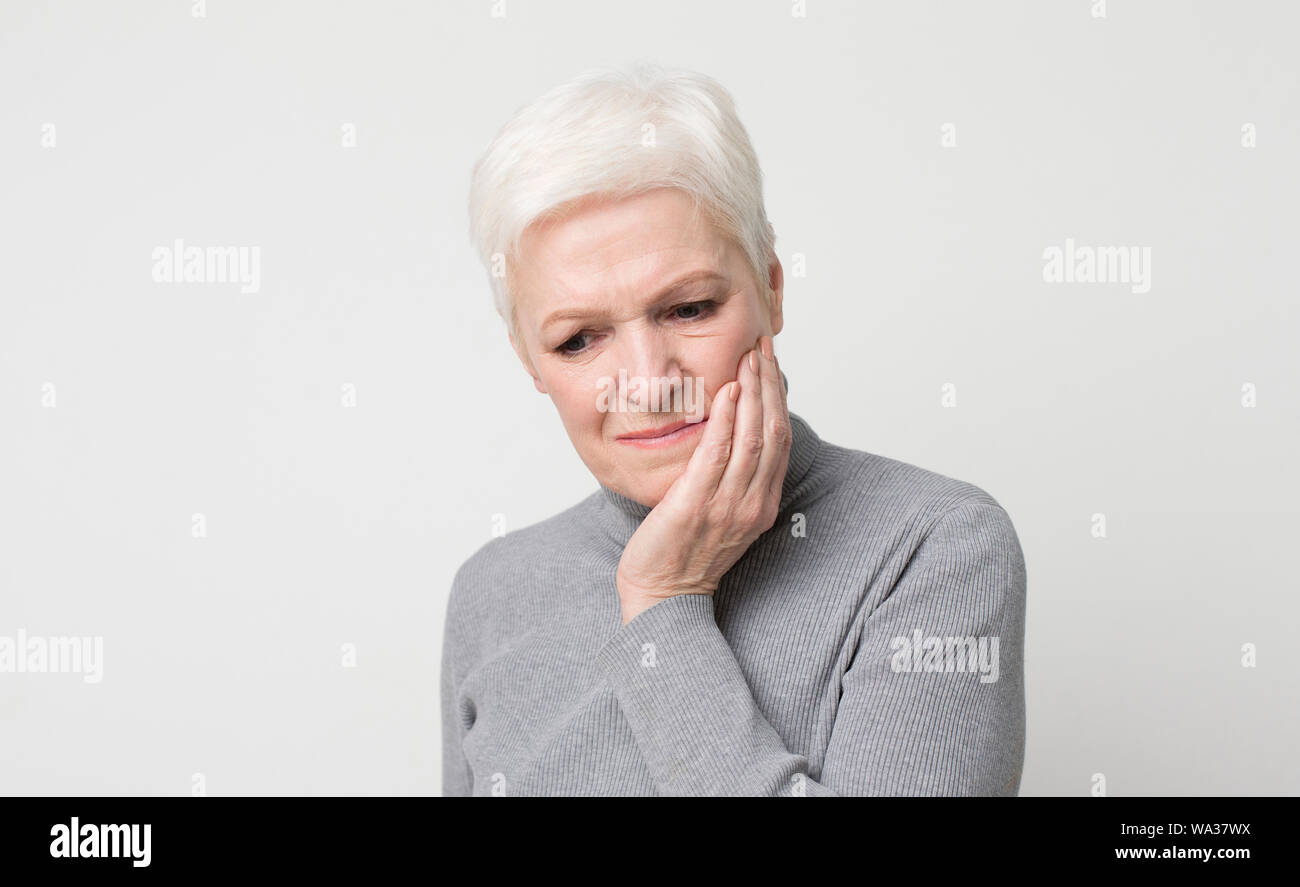 Elderly woman suffering from sudden tooth pain, panorama Stock Photo