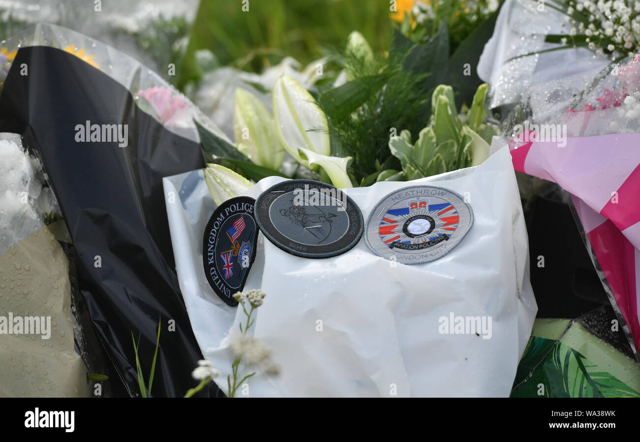 Badges on floral tributes at the scene, where Thames Valley Police officer Pc Andrew Harper, 28, died following a 'serious incident' at about 11.30pm on Thursday near the A4 Bath Road, between Reading and Newbury, at the village of Sulhamstead in Berkshire. Stock Photo