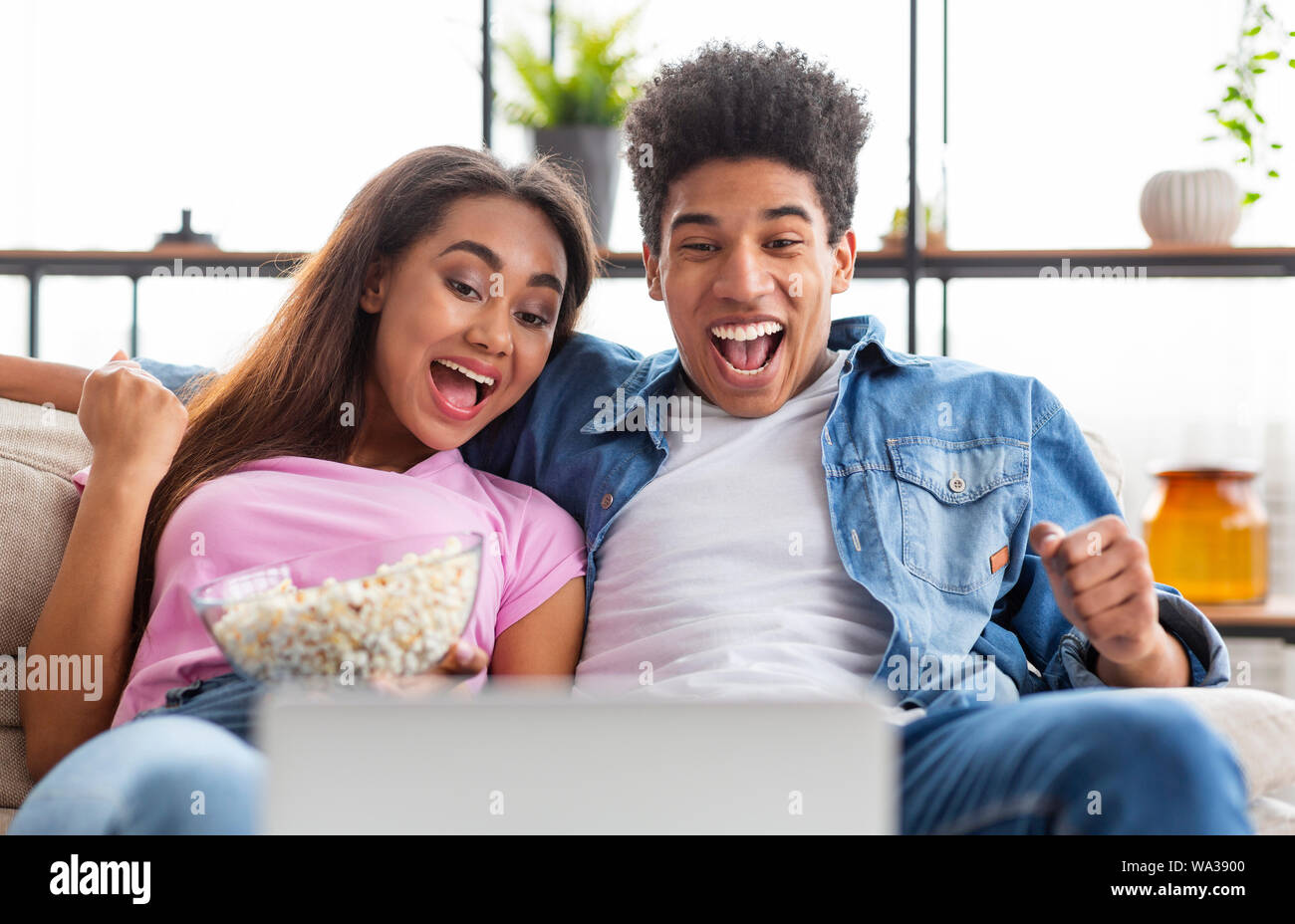 Laughing teenagers watching funny video on laptop Stock Photo