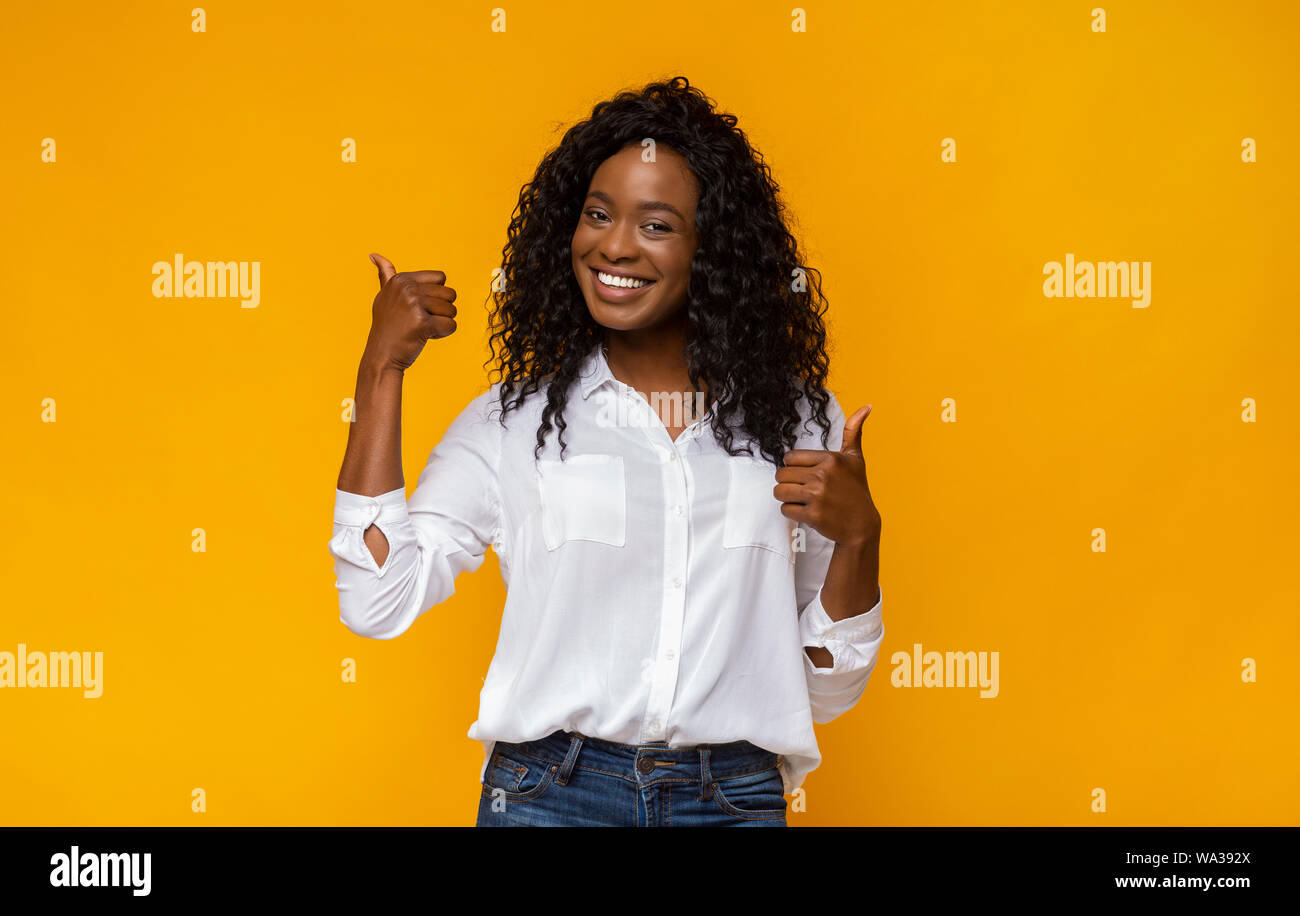 Happy black woman showing thumbs up at studio Stock Photo - Alamy