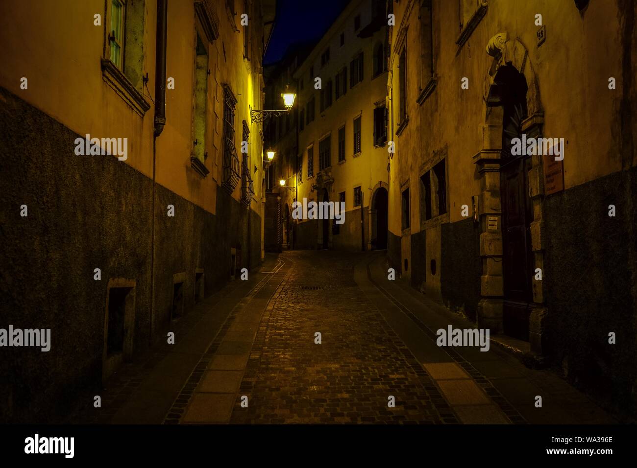Alleyway In The Middle Of Buildings With Lit Street Lights At Night Time Stock Photo Alamy