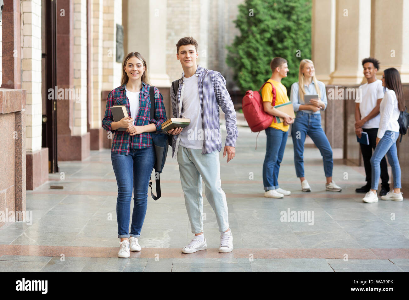 Happy students in university campus smiling to camera Stock Photo