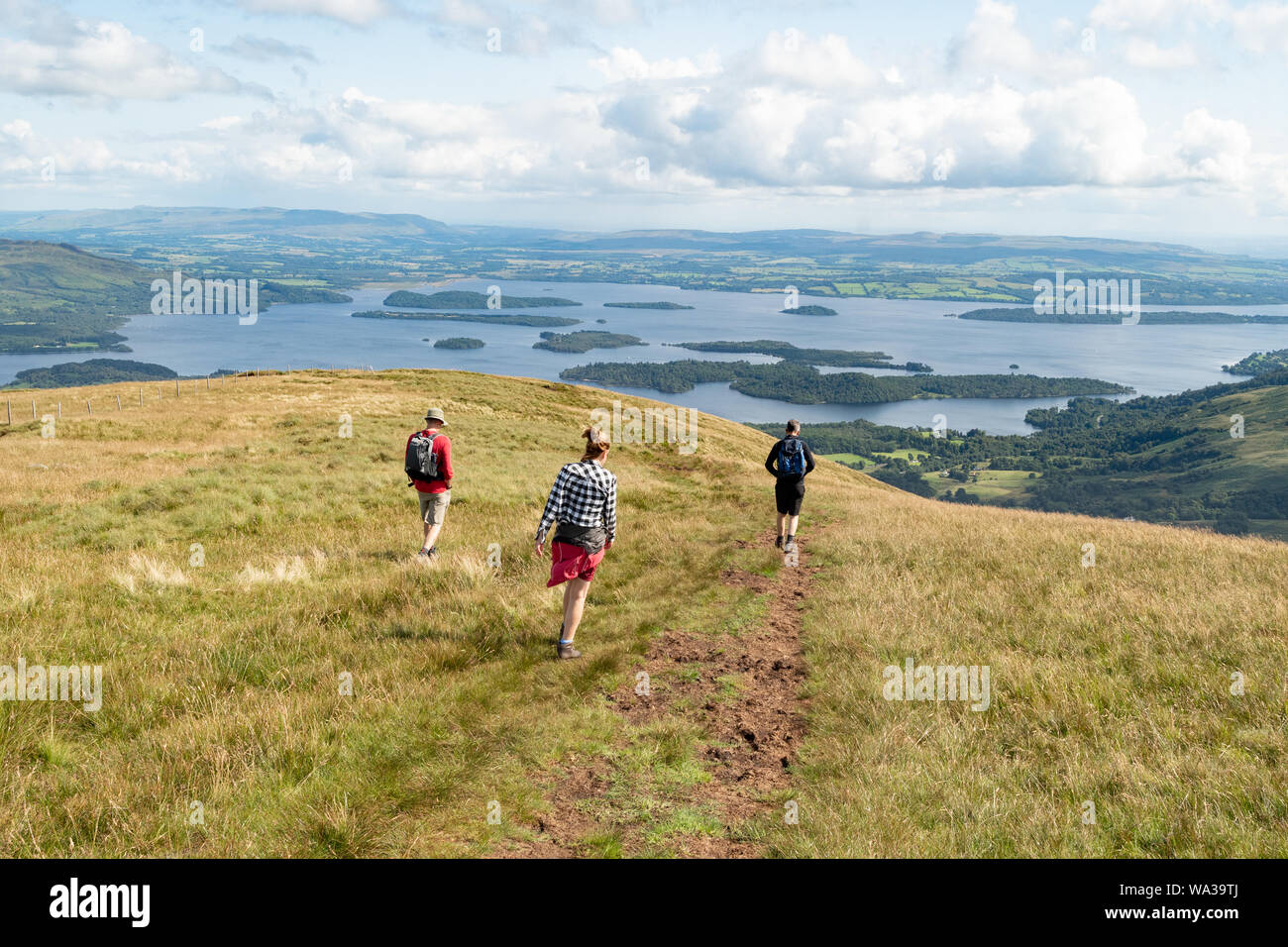 walkers decending Beinn Dubh, the highest point of the Glen Striddle hills near the village of Luss,  with views over Loch Lomond, Scotland, UK Stock Photo