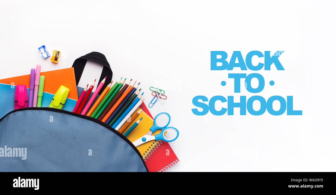 School backpack with colored stationery on white background Stock Photo
