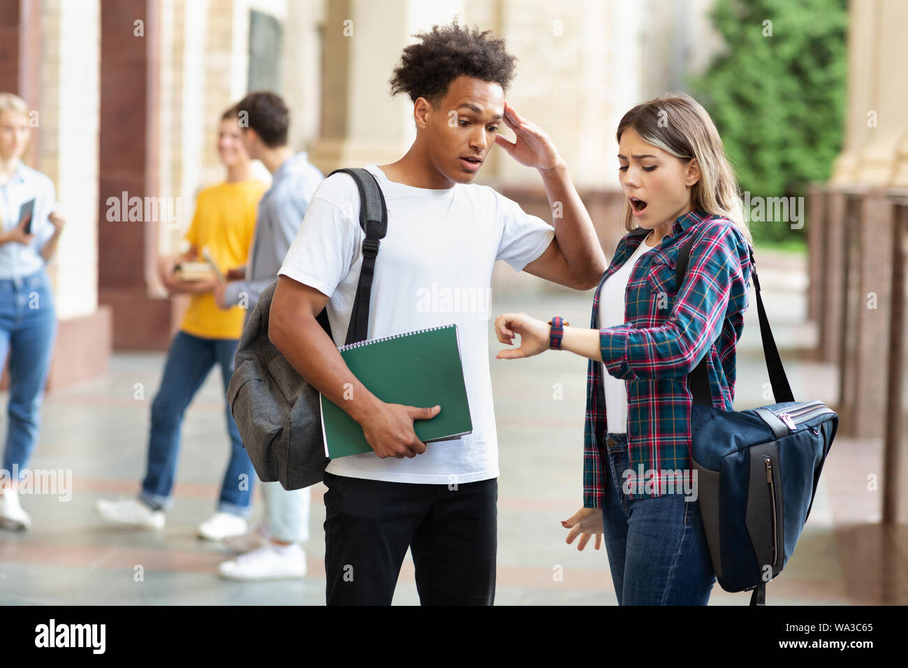 Hurry up! Multiracial students in university campus Stock Photo