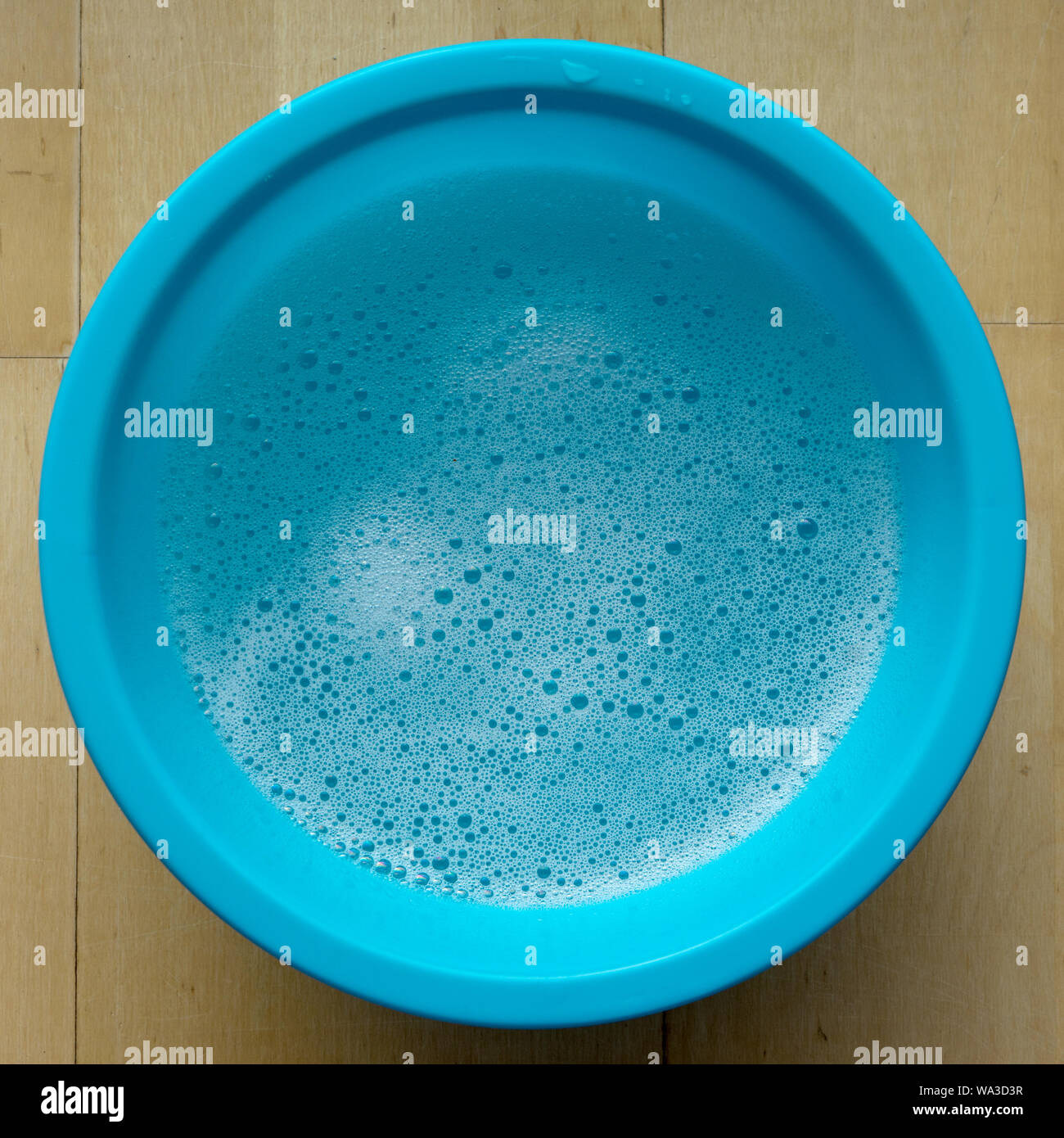 Blue bowl with soapy water and foam Stock Photo