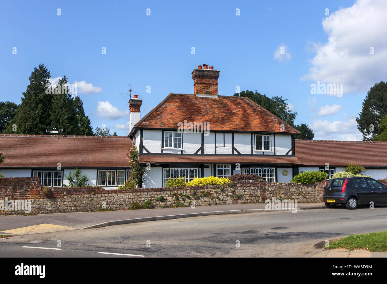 Roadside view of a large white detached timbered house 'Hatchers' by