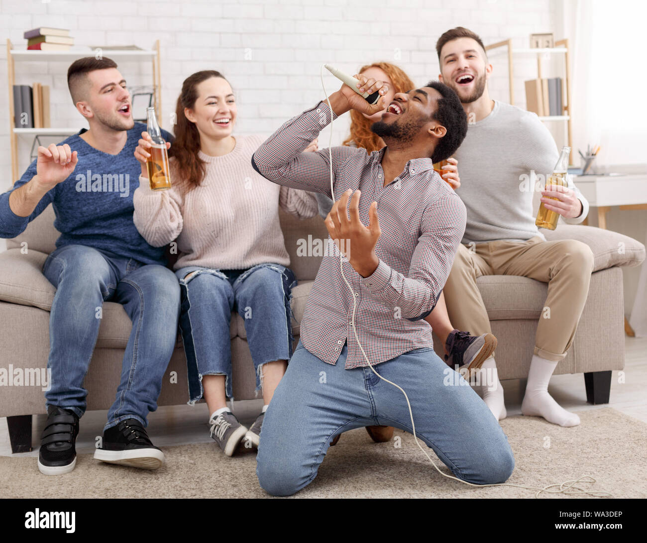 Karaoke party concept. Happy friends singing at home Stock Photo