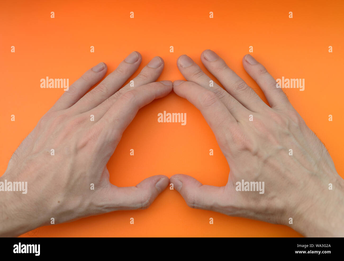 Hand sign heart on orange background. Stock Photo
