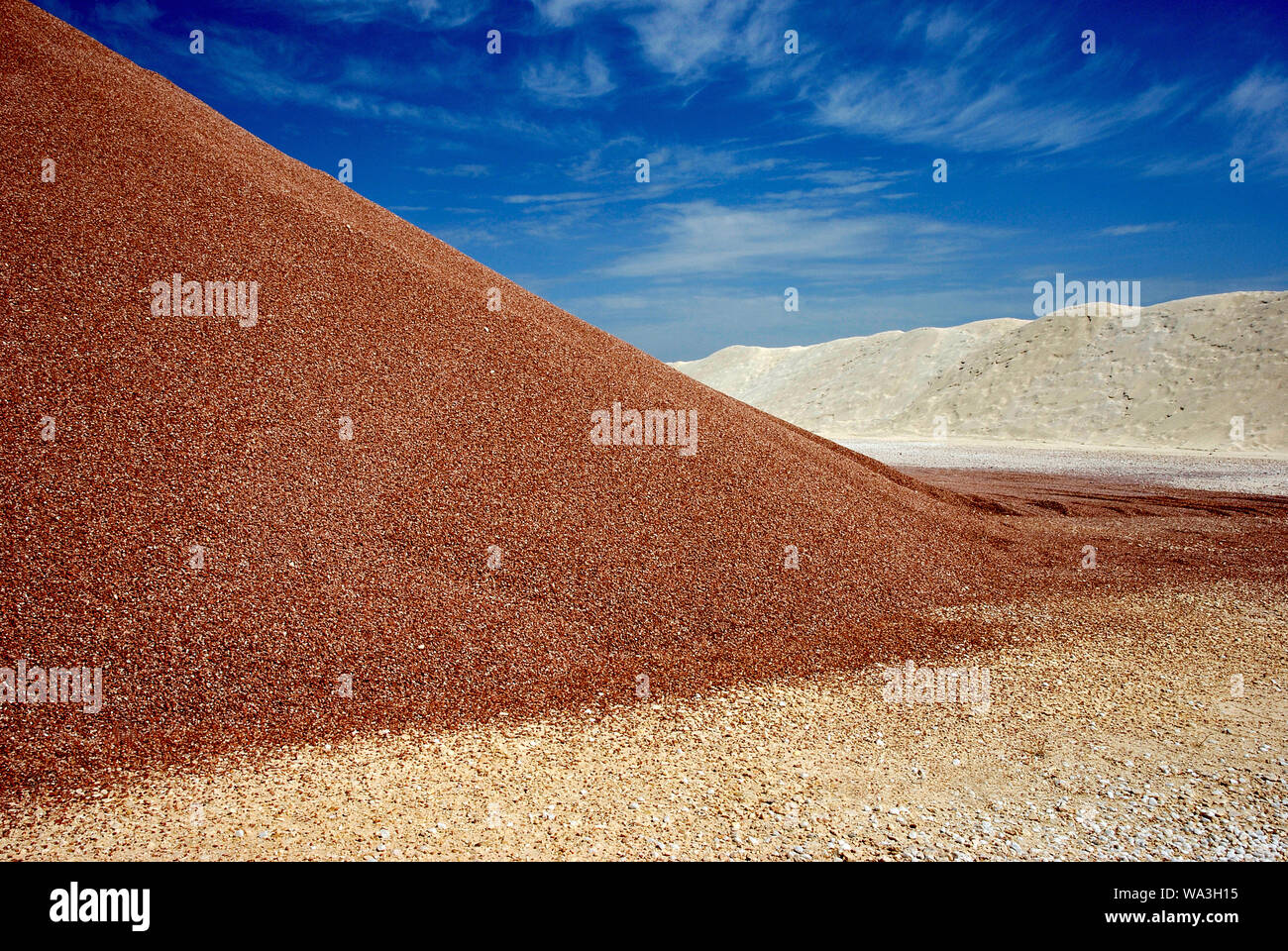 brown and white sandheaps under blue sky in mine at high noon Stock Photo