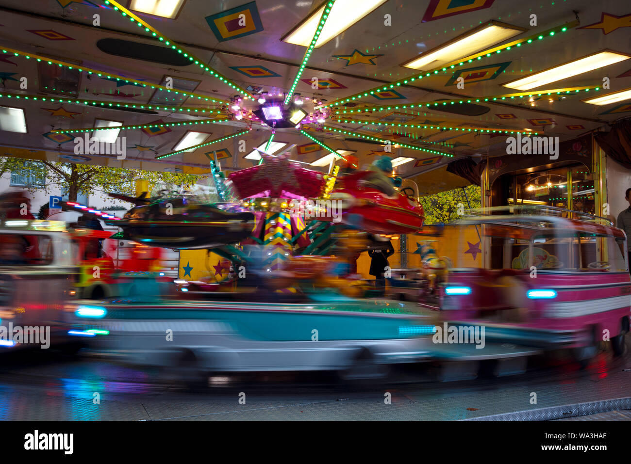 children's carousel with cars and planes at the christmas funfair market, long time exposure with blurred motion, abstract background, copy space Stock Photo