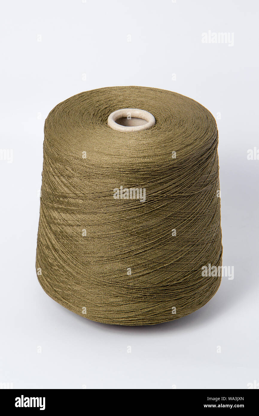 Brown bobbin of yarn on a white background. Side view.Textile reel on