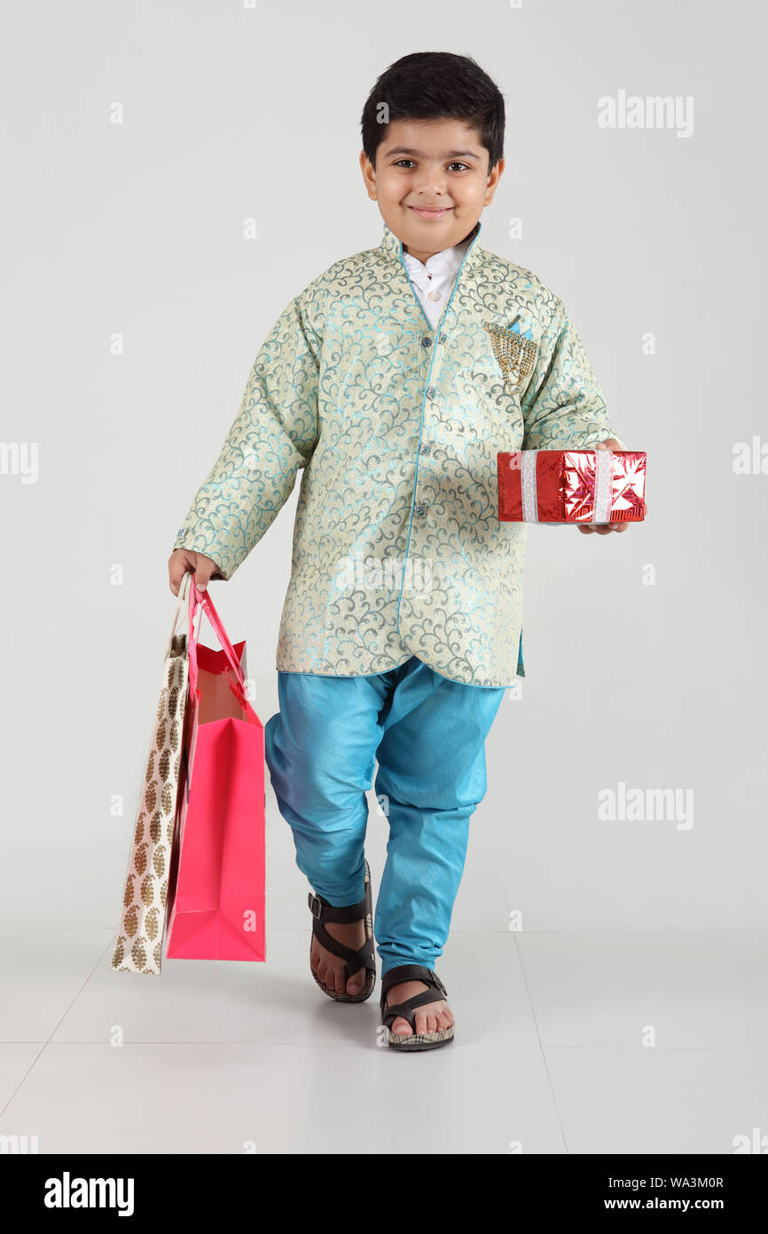 Boy holding a gift box with shopping bags and smiling Stock Photo Alamy