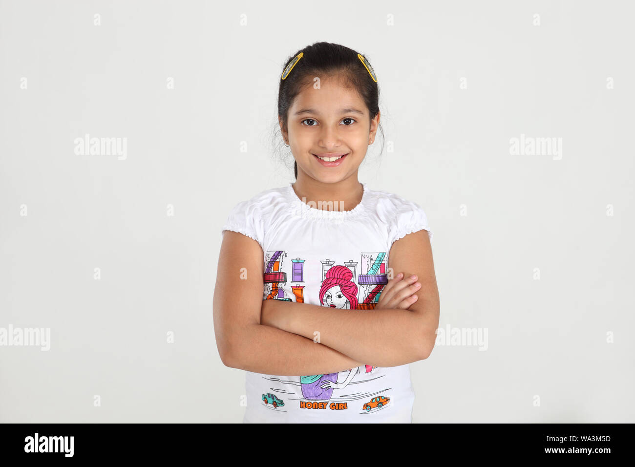 Girl standing with her arms crossed and smiling Stock Photo - Alamy