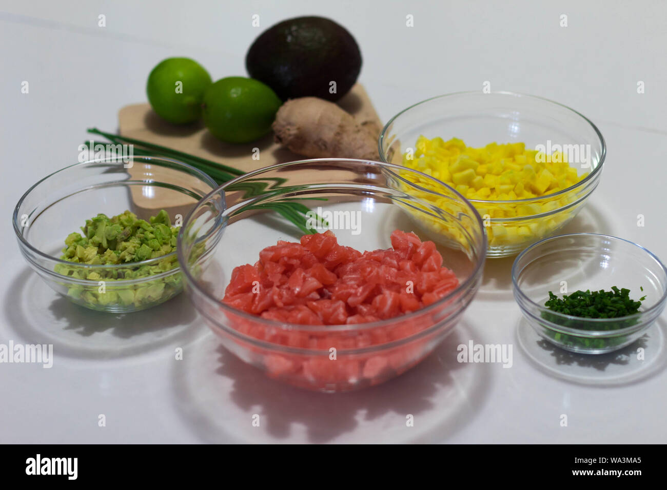I took this photograph the ingredients chopped and prepared to cook a salmon tartar. These ingredients are avocado, mango, salmon, chives, lime and gi Stock Photo