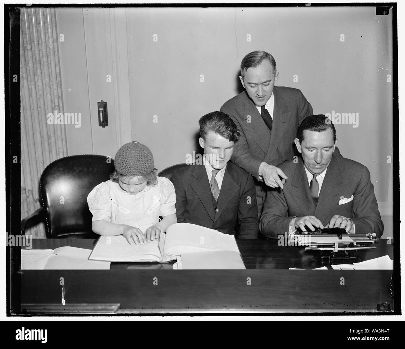 Blind youngsters display ability before Senate Committee. Washington, D.C. April 9. Blind children from the Maryland School for the Deaf, Dumb and Blind coaching Senator Claude Pepper, of Florida, in the art of operating a braille typewriter. The youngsters appeared before the senate subcommittee on education and labor, of which Senator Pepper is Chairman, as an example of what can be done for physically handicapped children if a bill sponsored by the International Society of Crippled Children is passed. The bill provides for the education of all types of physically handicapped children. It ap Stock Photo