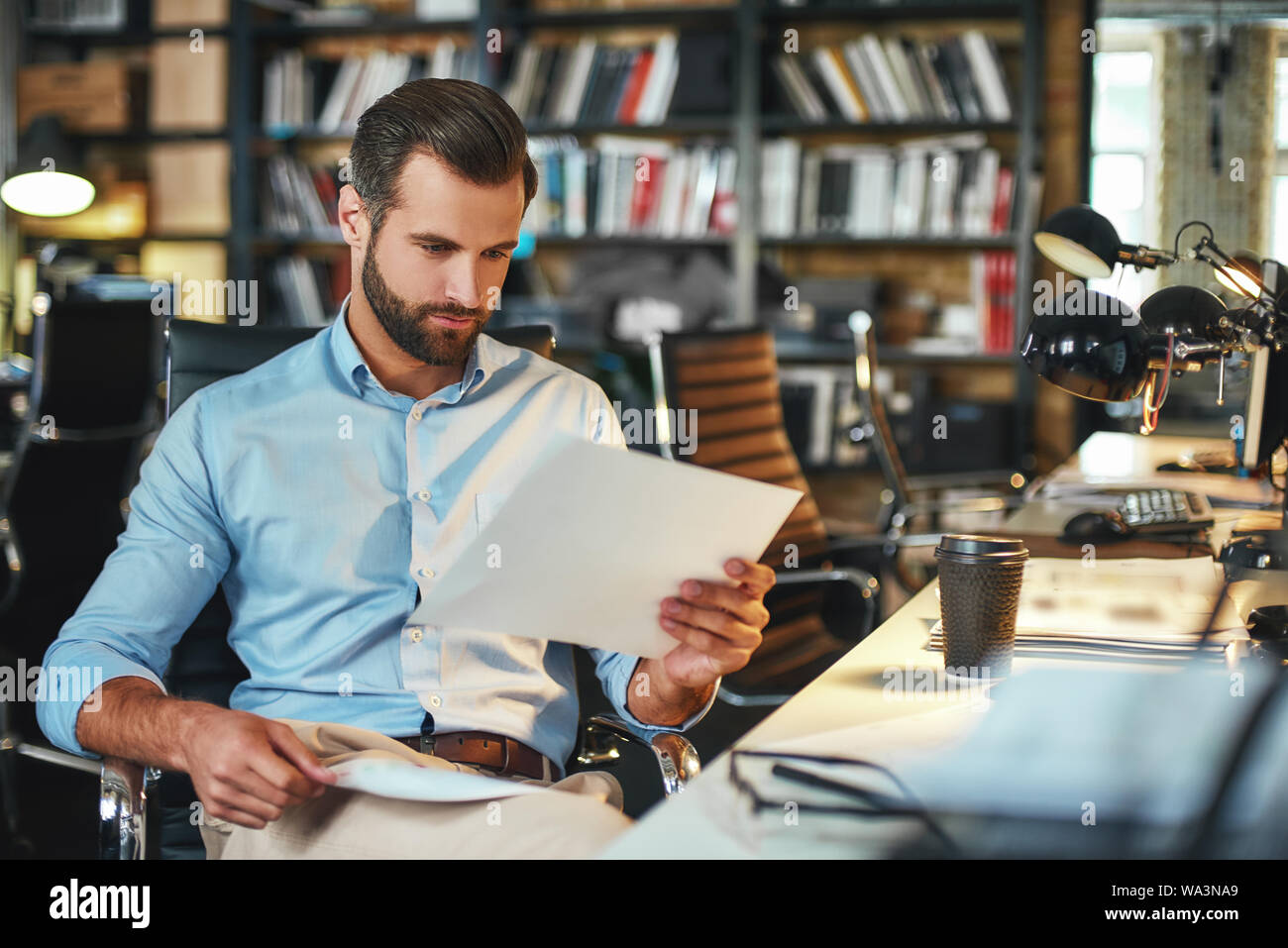 Let me see. Young and handsome bearded man in formal wear examining ...