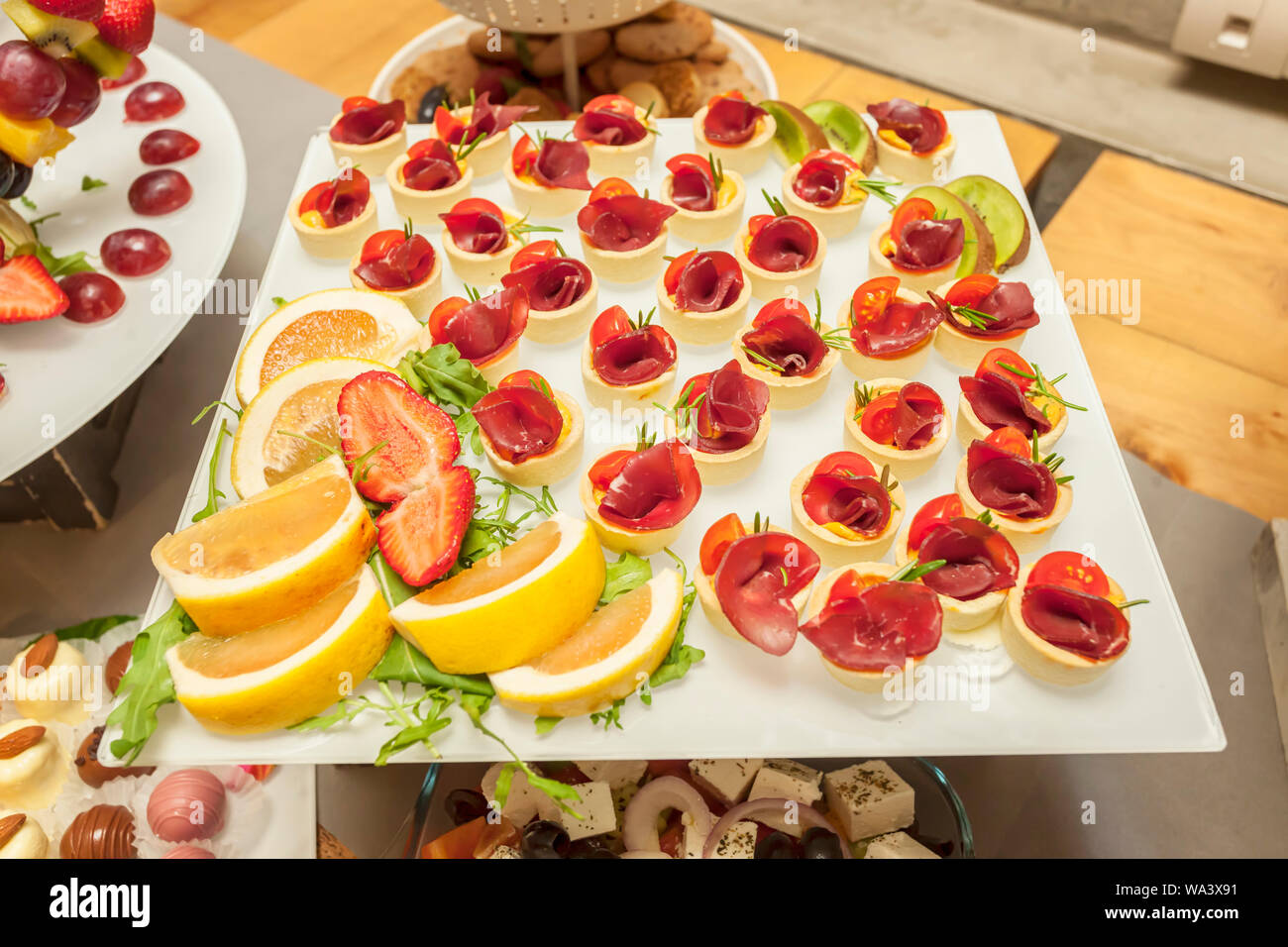 Prosciutto and rosemary with melted cheddar cheese Canape - single bite serving - arranged party finger food - cold buffet Stock Photo