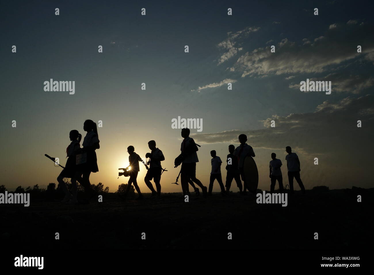 (190817) -- NEIQIU, Aug. 17, 2019 (Xinhua) -- Crew members come back to school after finishing shooting in Neiqiu County, north China's Hebei Province, Aug. 15, 2019. Beiling Central Primary School is located in hilly region in Neiqiu. Over half of the students in the school are left-behind children. To enrich children's life, the school established a film studio called "Starlight" in 2014, and encourages students to make micro films. So far, the studio has completed 7 films and is working on one about left-behind children's self-reliance. With teachers as directors and students as actors Stock Photo