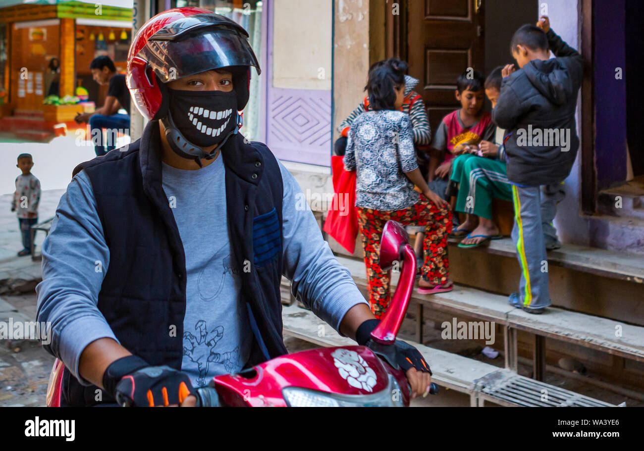 Kathmandu, Nepal  November 02,2017: young asian man on a motorbike with a funny breathing protection around his face Stock Photo