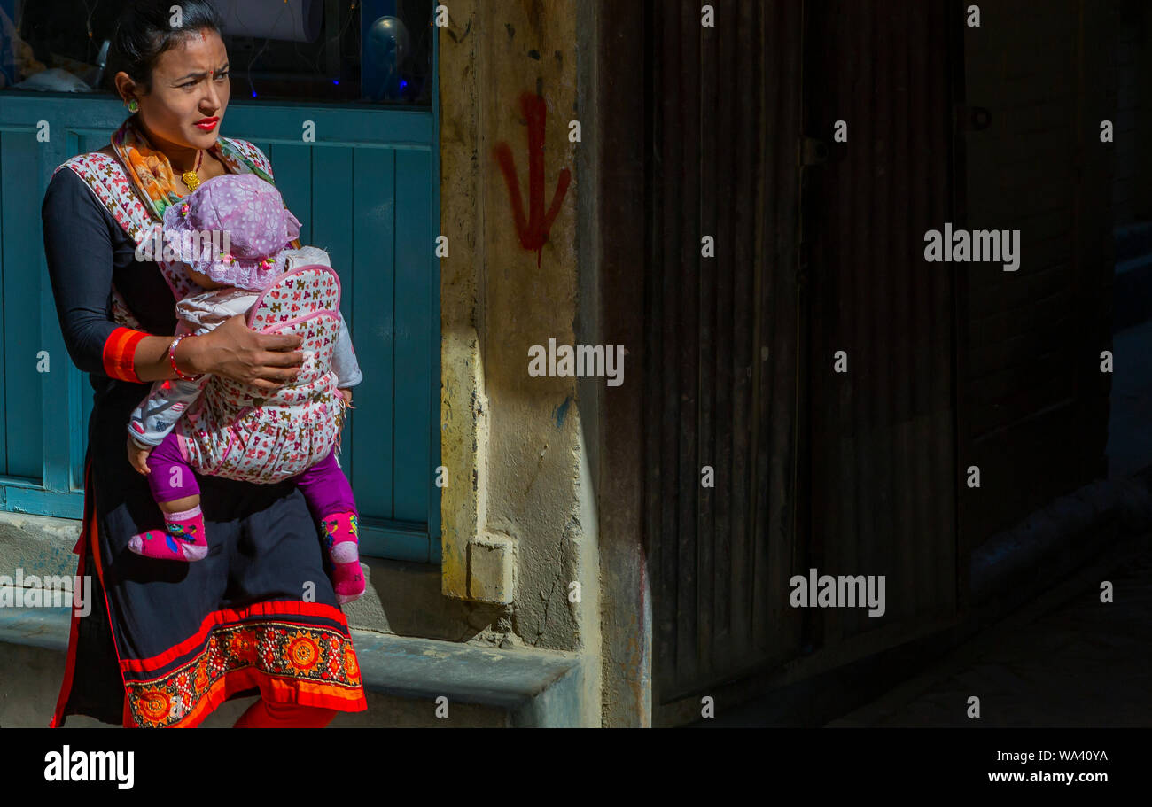 Kathmandu, Nepal-November 02,2017: young Nepali  women carries her baby in a baby sling Stock Photo