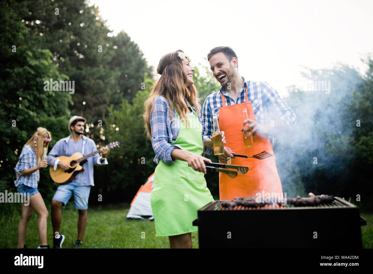 Group of happy friends having barbecue party in forest Stock Photo - Alamy