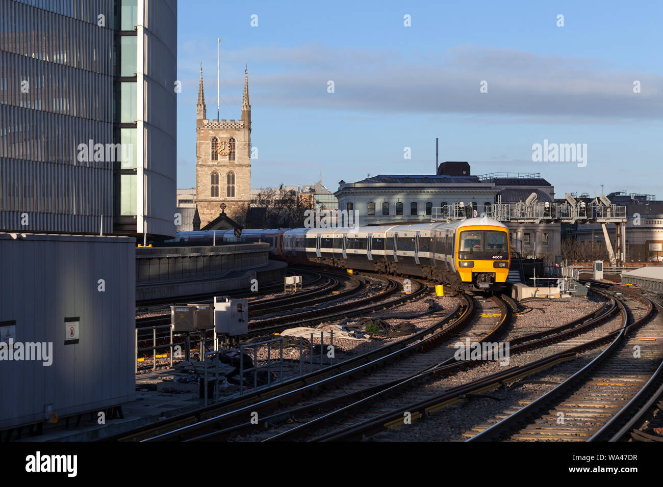 South Eastern trains class 465 trains passing London Bridge with Southwark cathedral behind Stock Photo