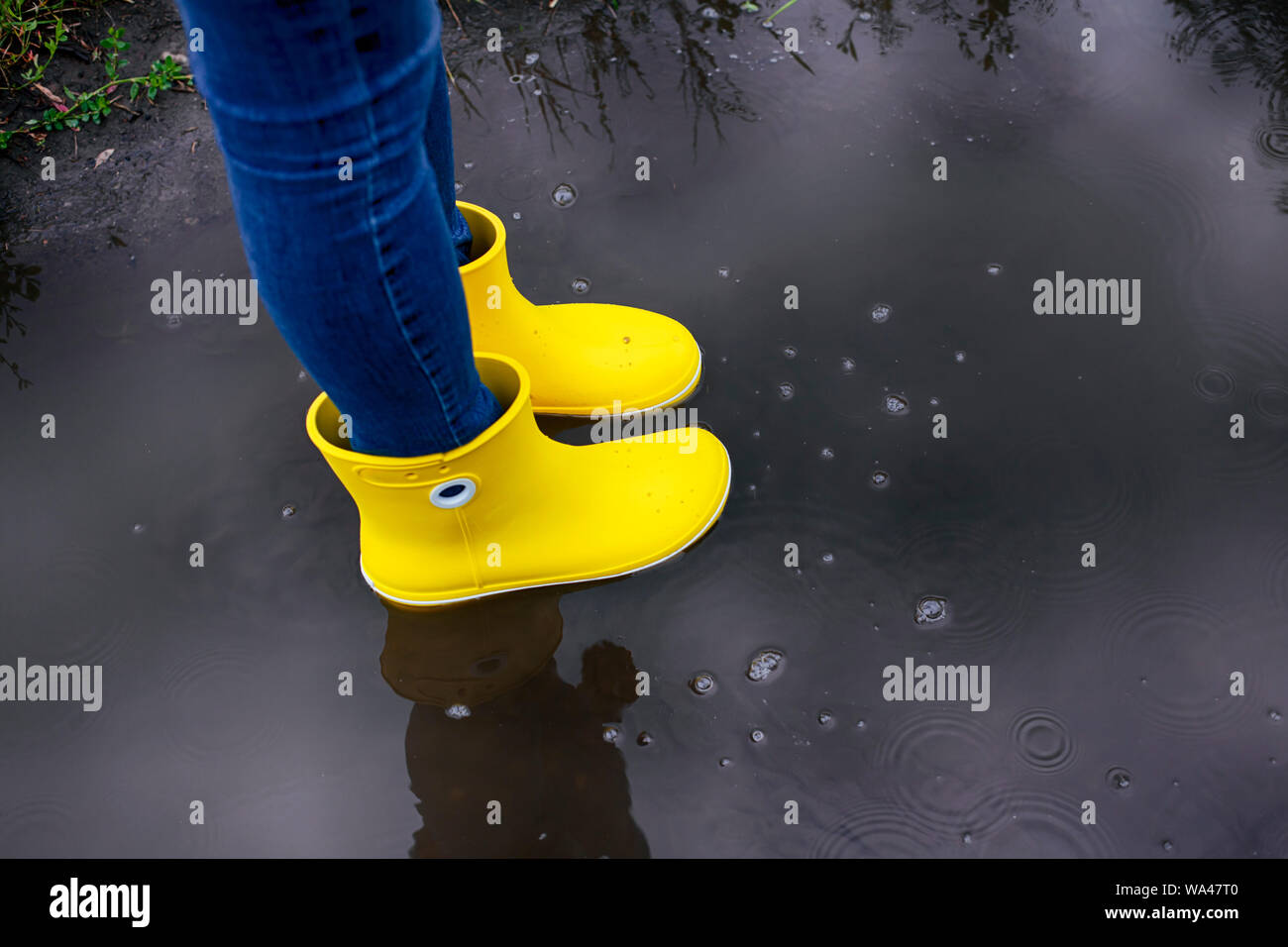 Woman in yellow rubber boots standing in the puddle Stock Photo - Alamy