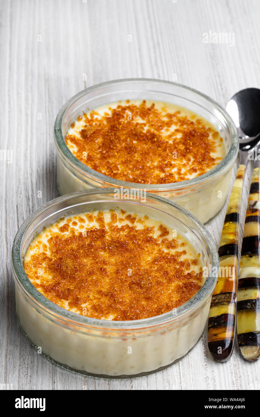 Closeup of creme brulee in glass jars on white wooden table Stock Photo -  Alamy