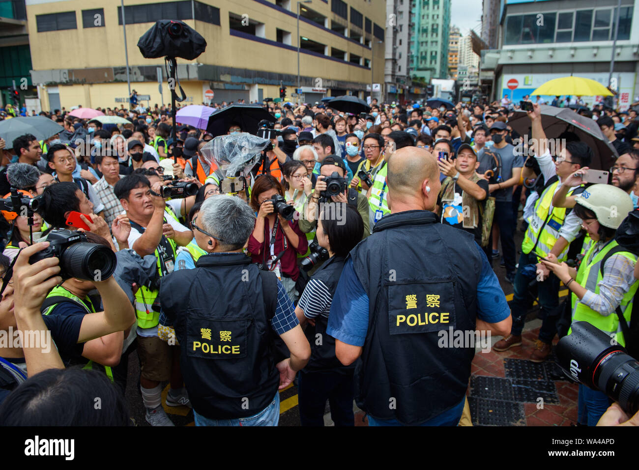 Hong Kong, China. 17th Aug, 2019. Two policemen are surrounded by demonstrators and representatives of the press during a demonstration. New protest weekend in Hong Kong: Tens of thousands of democracy supporters again pull through the city. And on this Sunday (18.08.2019) there will be even more. Credit: Gregor Fischer/dpa/Alamy Live News Stock Photo