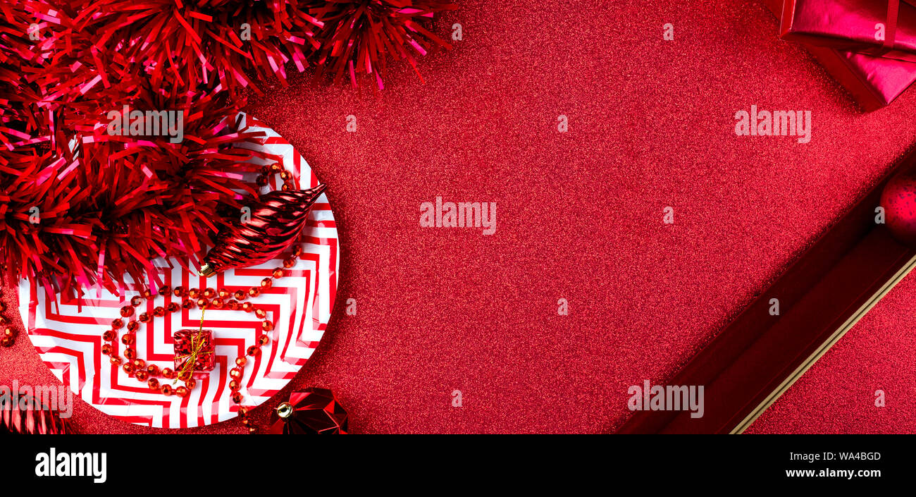 Merry christmas and happy new year red background.top view of tinsel,gift box,ball,ribbon decorate on sparkling table.holiday celebration greeting car Stock Photo