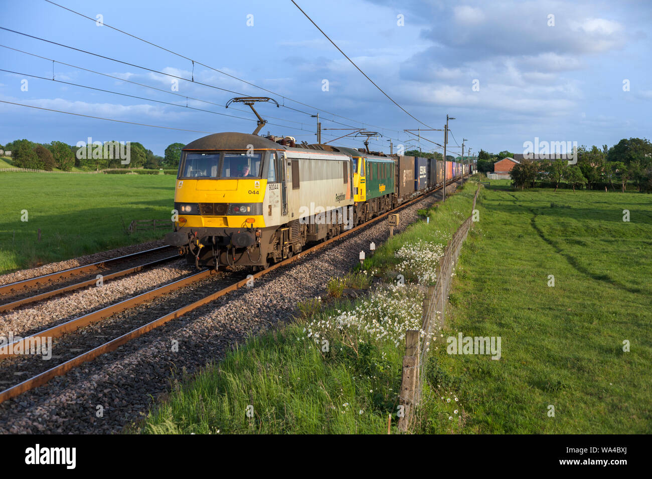 2 Freightliner class 90 electric locomotives on the west coast mainline in Lancashire with a domestic intermodal container train Stock Photo