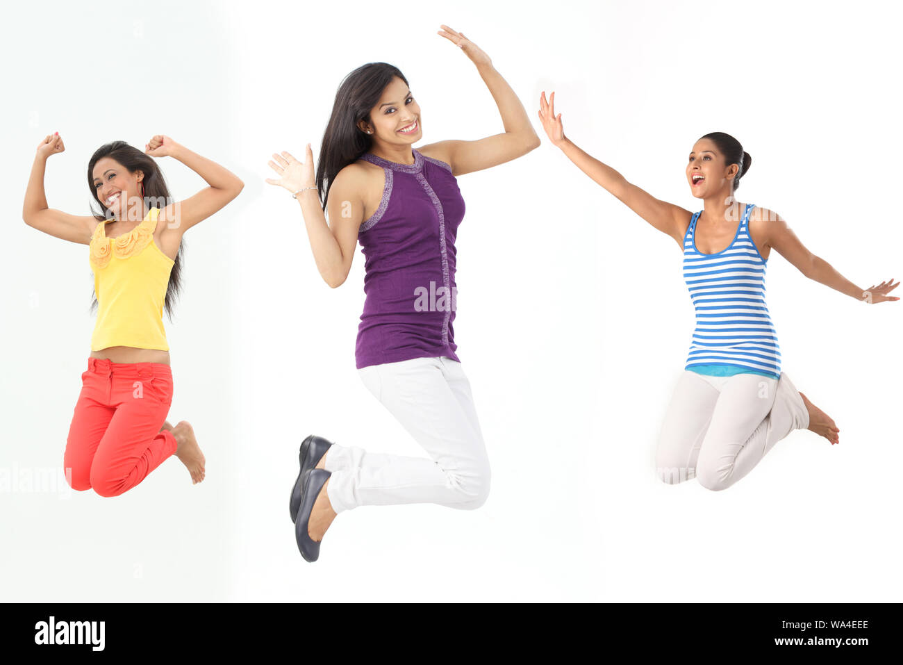 Young women jumping in air and smiling Stock Photo - Alamy
