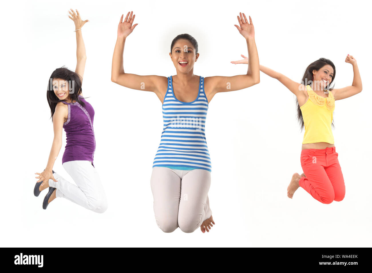 Young women jumping in air and smiling Stock Photo - Alamy