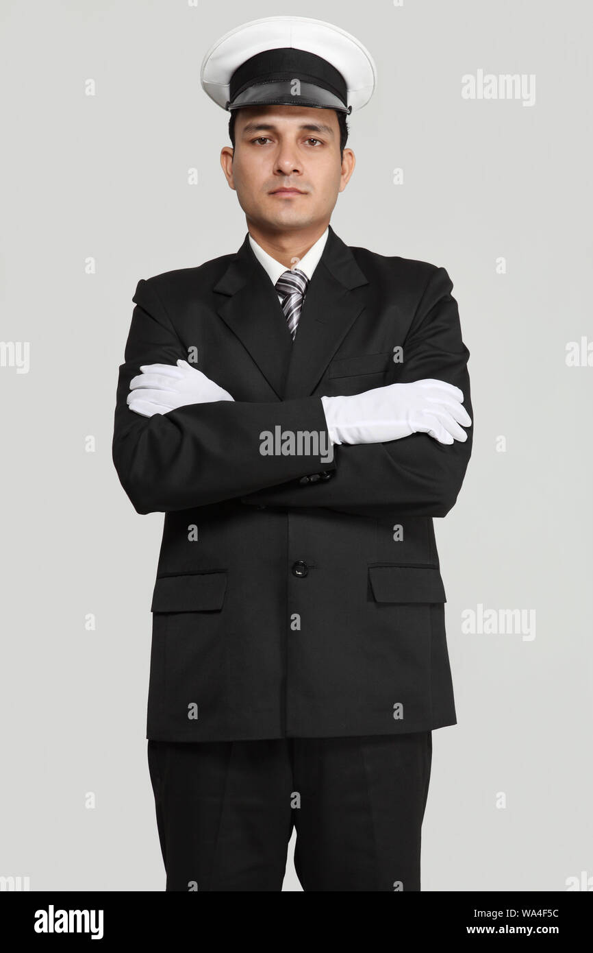 Chauffeur standing with his arms crossed Stock Photo