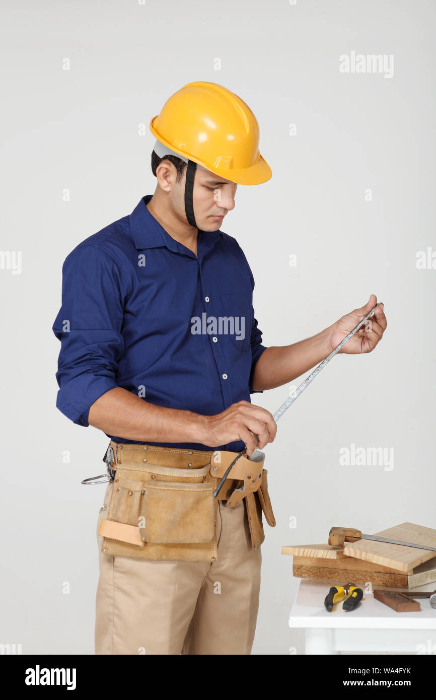 Carpenter with measuring tape Stock Photo