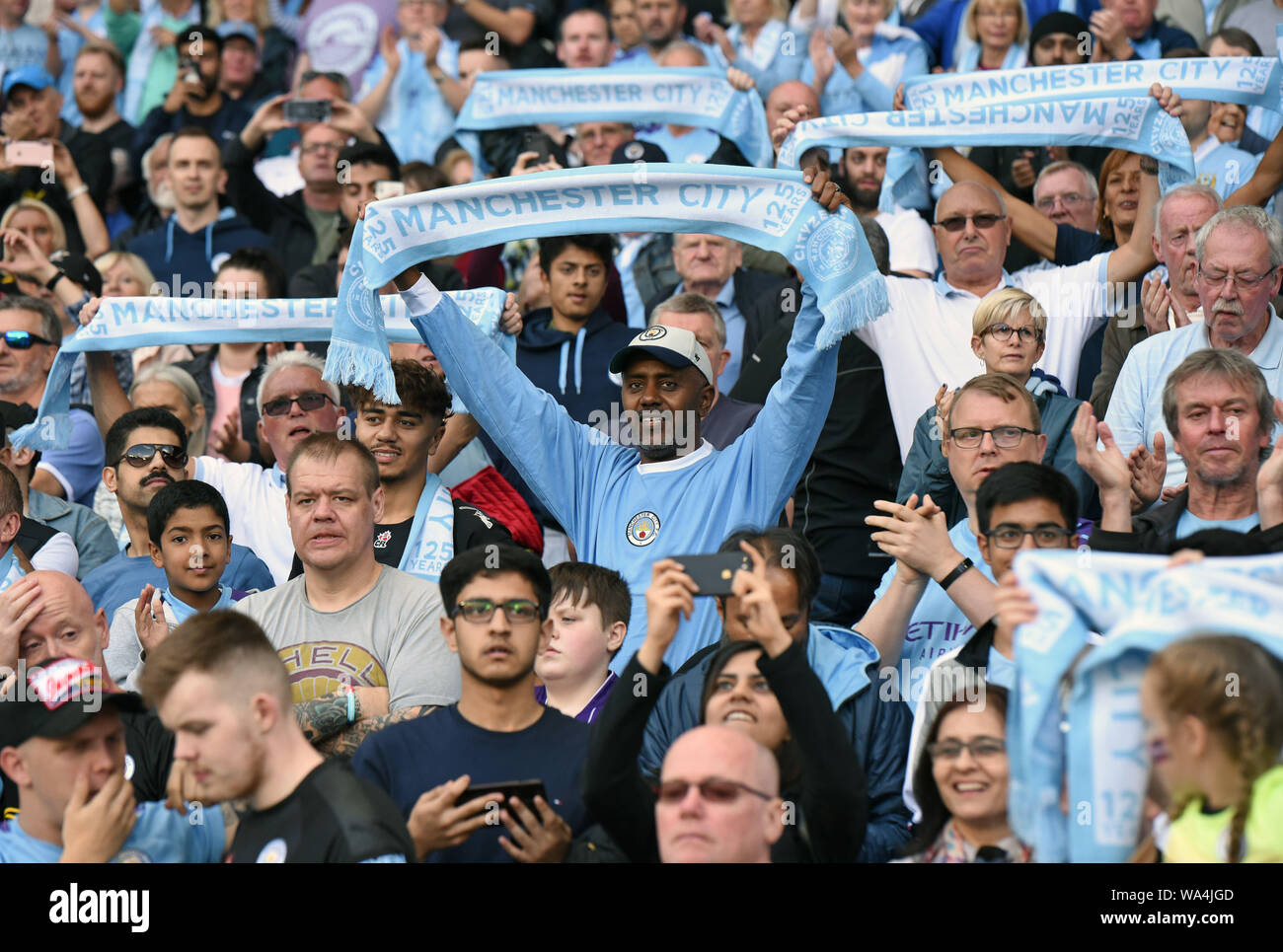 17th August 2019; Etihad Stadium, Manchester, Greater Manchester, England; Manchester City versus Tottenham Hotspur; Manchester City fans hold their scarves above head before the game - Strictly Editorial Use Only. No use with unauthorized audio, video, data, fixture lists, club/league logos or 'live' services. Online in-match use limited to 120 images, no video emulation. Stock Photo