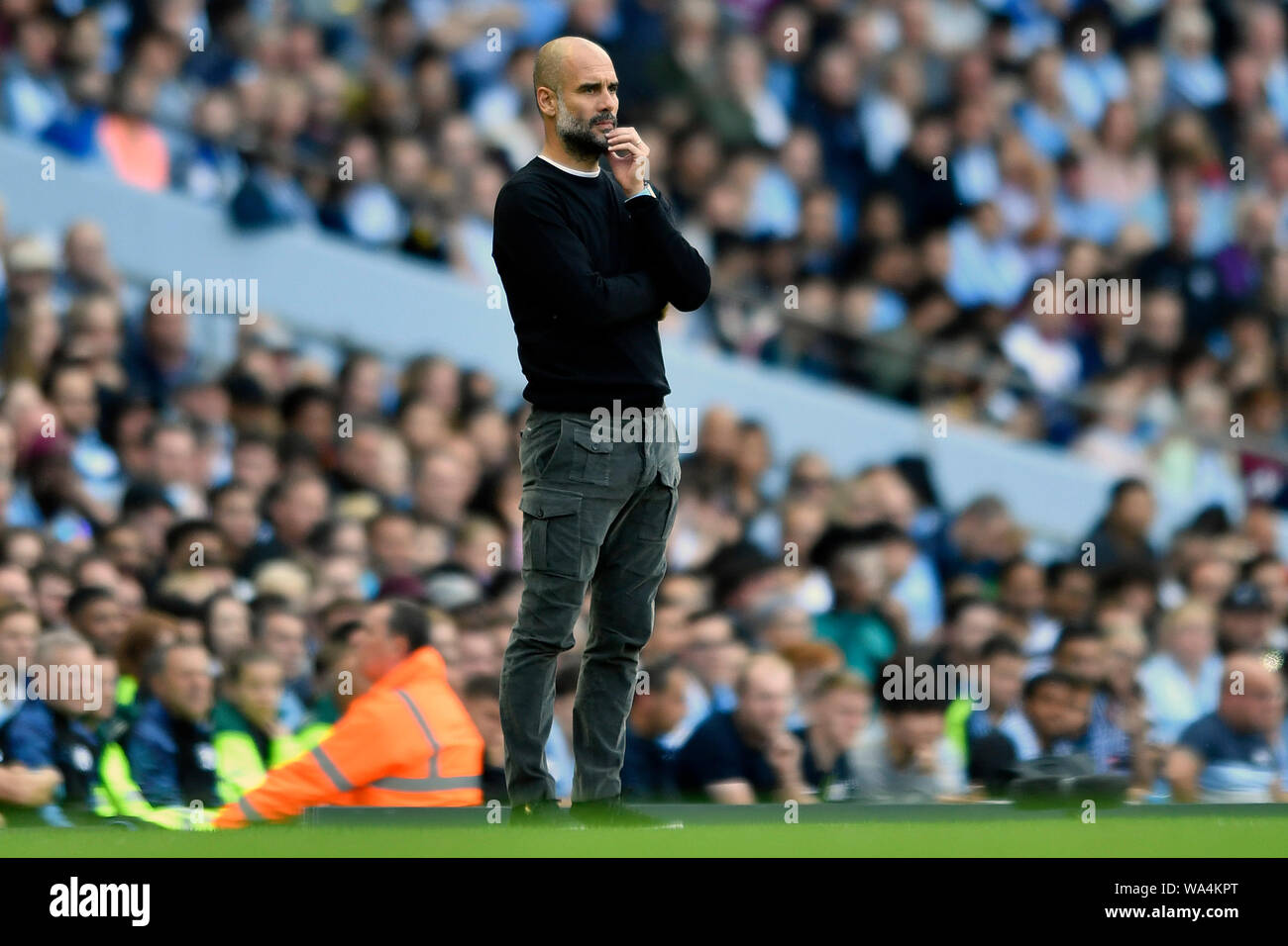 17th August 2019; Etihad Stadium, Manchester, Greater Manchester, England; Manchester City versus Tottenham Hotspur; Pep Guardiola, Manager of Manchester City considers his options from the sideline - Strictly Editorial Use Only. No use with unauthorized audio, video, data, fixture lists, club/league logos or 'live' services. Online in-match use limited to 120 images, no video emulation. Stock Photo