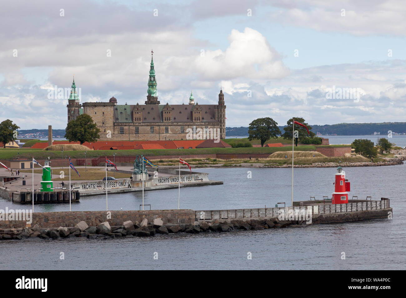 Kronborg Castle on the Kronborg point at the Sound Øresund, entrance to Elsinore, Helsingør, Harbour. Sweden in distance. A summer morning. Stock Photo