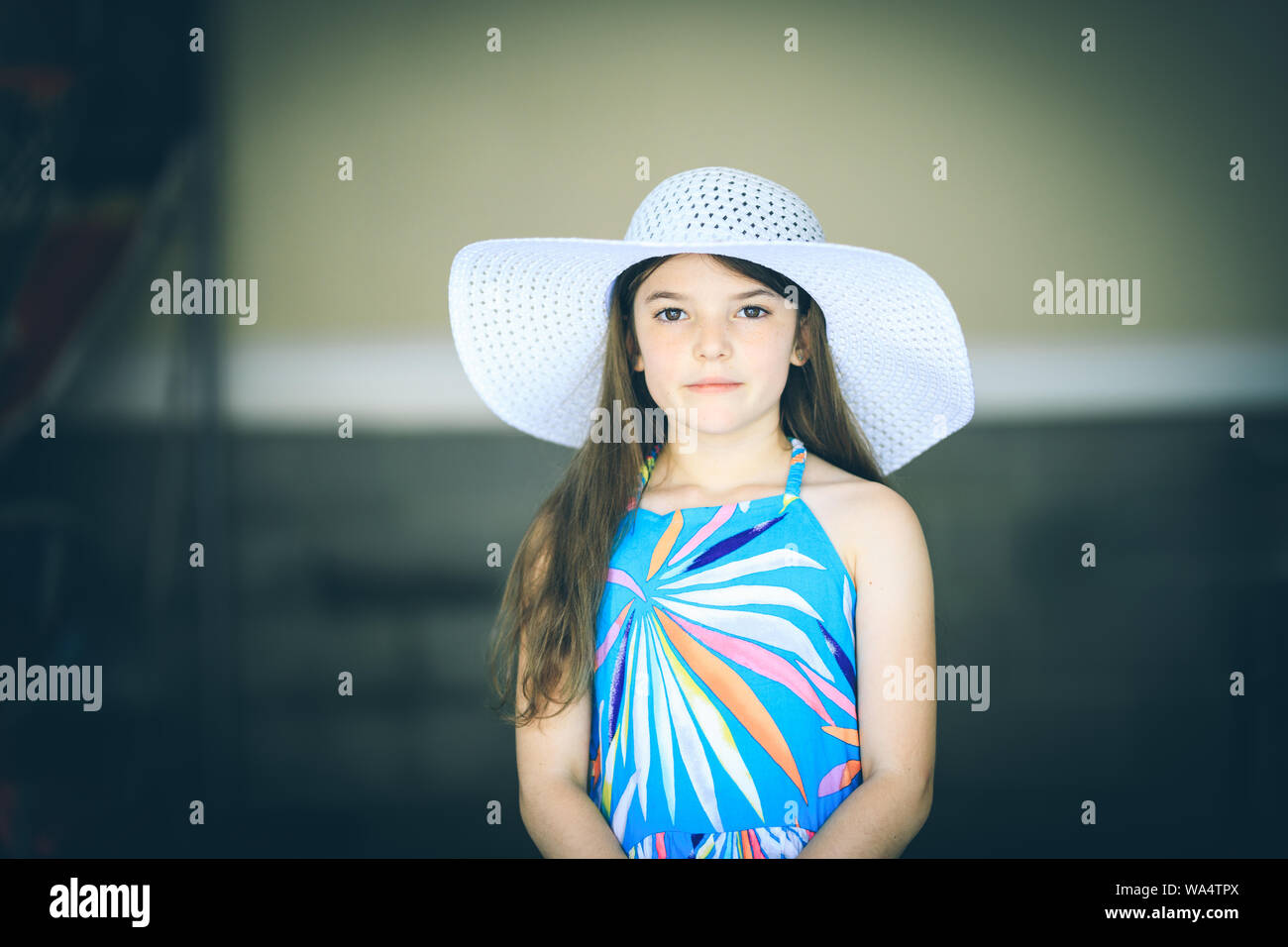Little girl in dress and big white hat Stock Photo