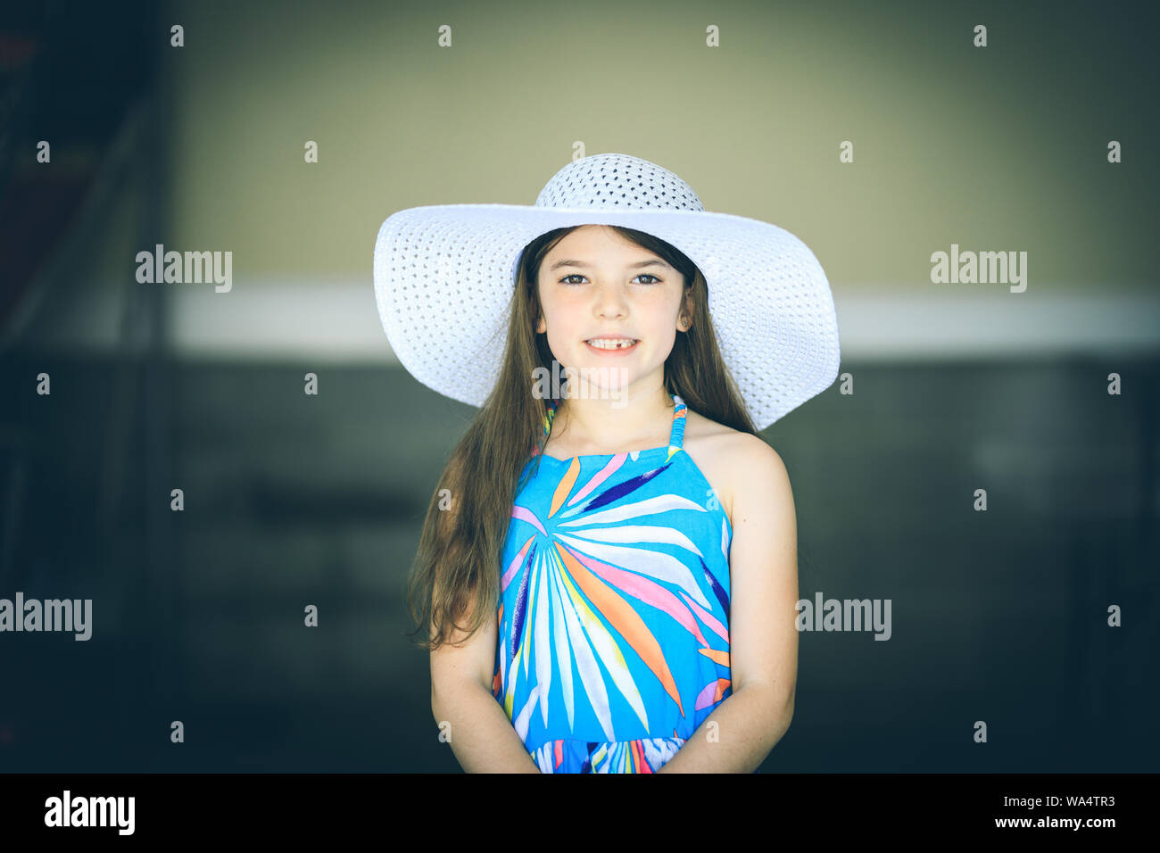 Little girl in dress and big white hat Stock Photo