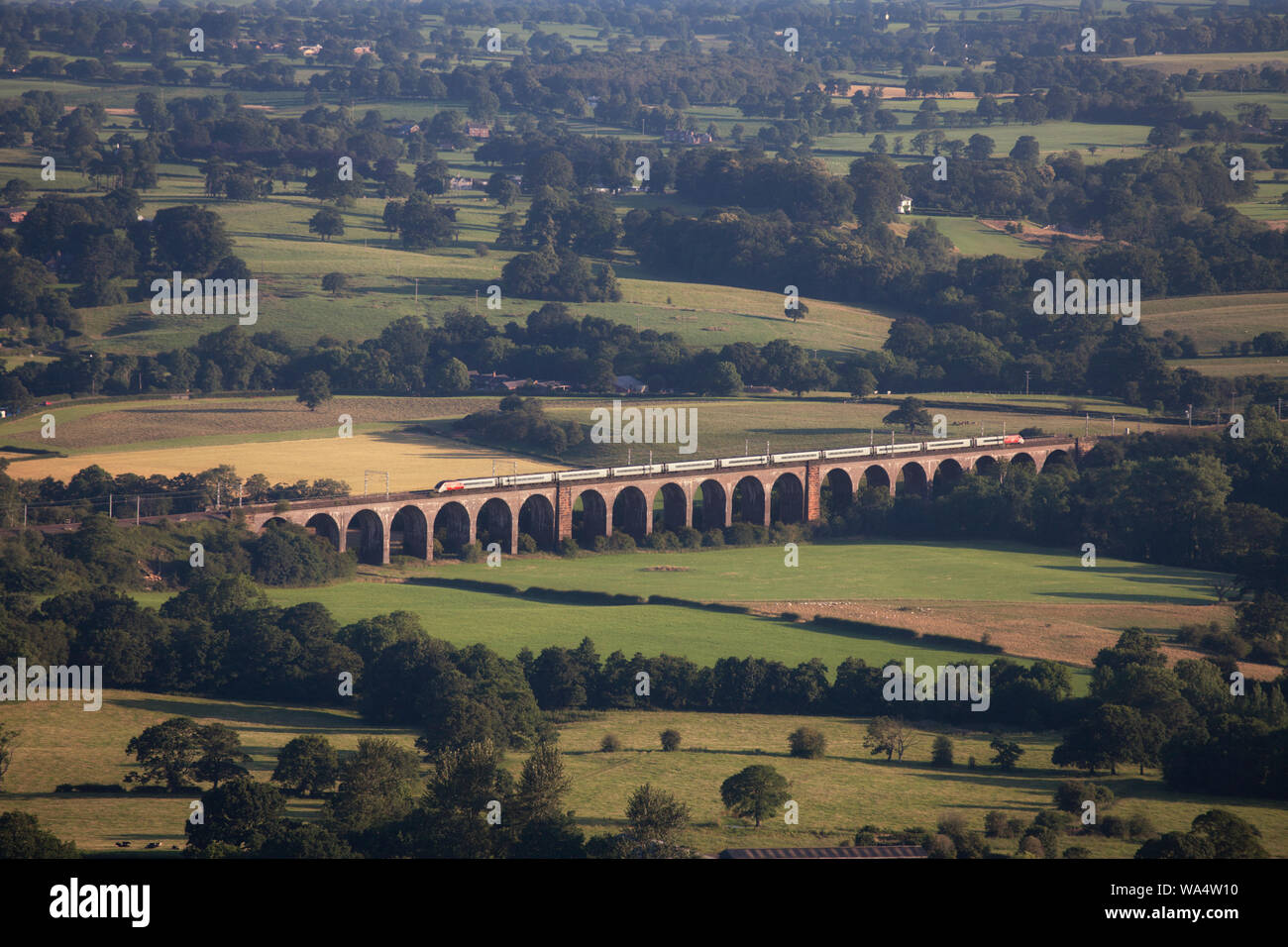 Virgin Trains Pendolino train crossing North Rode viaduct, north of Congleton, in the Cheshire countryside Stock Photo