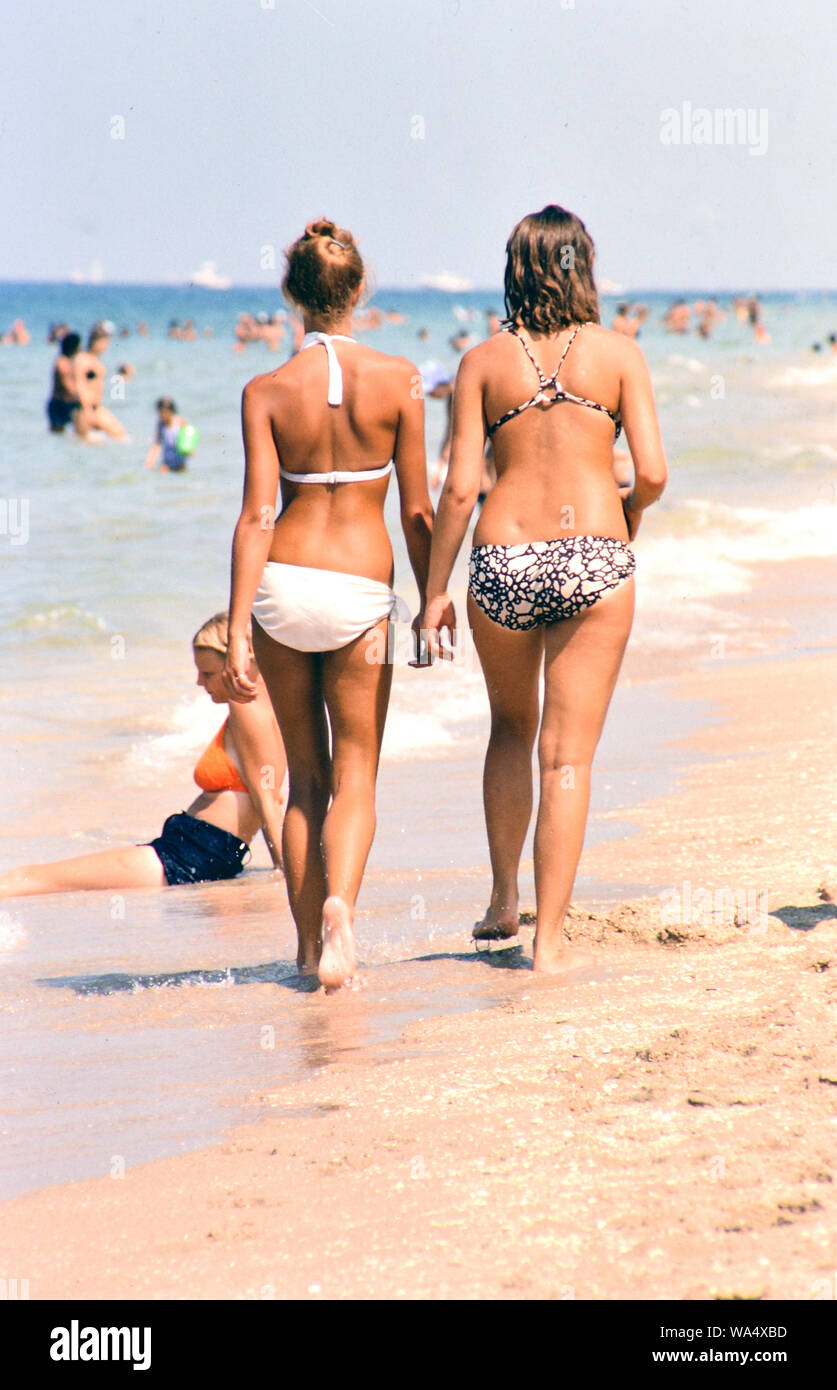 Two Beautiful Women Walking In Bikinis On A Florida Beach In The Late two-beautiful-women-walking-in-bikinis-on-a-florida-beach-in-the-late